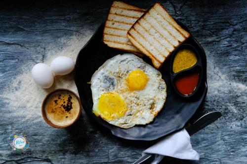 a breakfast plate with eggs and toast and coffee at Mitra Hostel Mcleodganj in McLeod Ganj