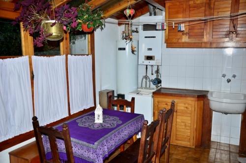 cocina con mesa y mantel púrpura en Casa Brown en San Martín de los Andes