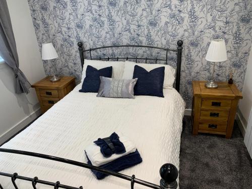 a bedroom with a large bed with blue and gray wallpaper at Ormasaig, Self Catering, One Mile to Town & close to Ben Nevis in Fort William