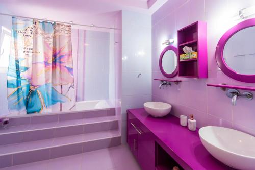 Baño rosa con lavabo y espejo en BLACK & WHITE CITY VILLA, en Alexandroupoli