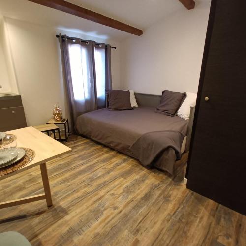 une chambre avec un lit et un parquet dans l'établissement Studio LA MOUTONNE tt équipé 20 m2 10mn plages- hyeres - TRES CALME-, à La Crau