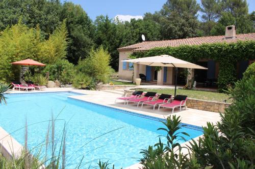 une piscine avec des chaises et un parasol dans l'établissement Villa en Provence, à Flayosc