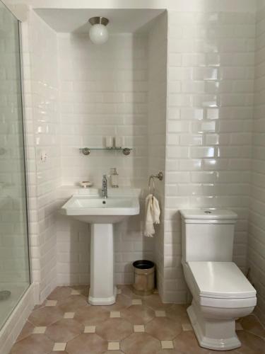 a white bathroom with a sink and a toilet at La Marquise in Bastia
