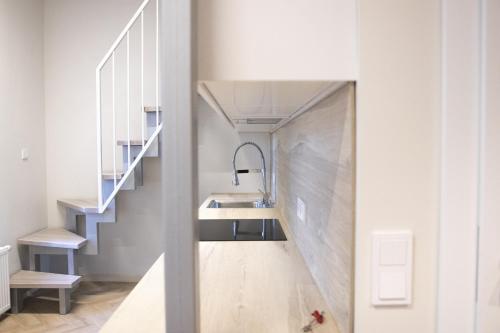a bathroom with a sink and a staircase at Sniego Apartments in Vilnius