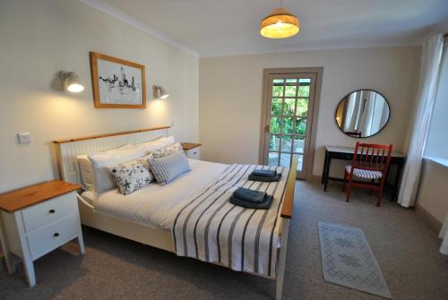 une chambre avec un lit, une table et un miroir dans l'établissement Sea Holly Cottage- coastal retreat Pittenweem, à Pittenweem