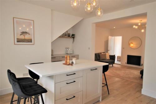 a kitchen and living room with a counter and chairs at Crows Neuk- fabulous coastal family home in Saint Monance