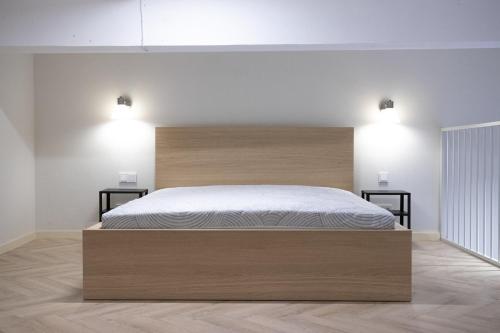 a bedroom with a large wooden bed with two lights at Sniego Apartments in Vilnius