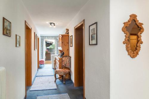 a hallway with a chair and a mirror on a wall at Ferienwohnung Dornauer in Hippach