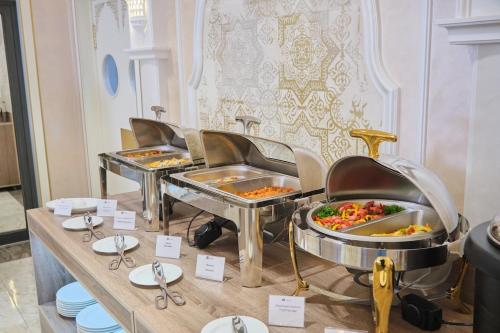 Al Anvar Halal Hotel by HotelPro group في طشقند: خط بوفيه مع صواني الطعام المعروضة