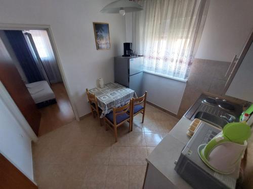 einen Blick über eine Küche mit einem Tisch und ein Esszimmer in der Unterkunft Apartmani Vuković in Kaprije