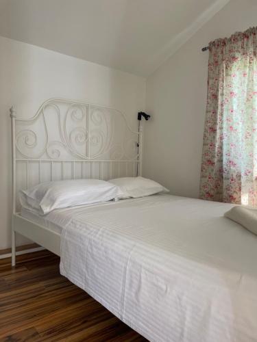 a bedroom with two beds with white sheets and a window at Apartment Jovana in Kotor
