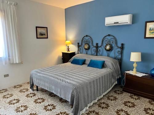 a blue bedroom with a bed with blue pillows at Villa Domus de Janna in Olbia