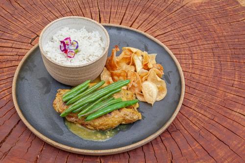 a plate of food with rice and vegetables and a bowl of rice at Capim do Mato Pousada & Spa by L'Occitane in Serra do Cipo