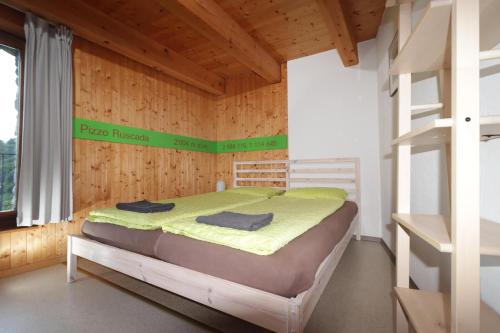 ein Schlafzimmer mit einem Bett in einem Holzzimmer in der Unterkunft Alla Capanna in Verdasio