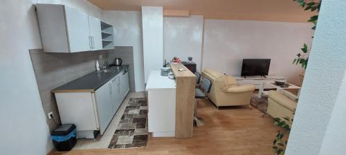 een kleine keuken met een wastafel en een bureau bij Apartman Citadel in Gradačac
