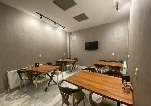 ウスパルタにあるHotel Altuğの木製のテーブルと椅子、薄型テレビが備わるレストランを提供しています。