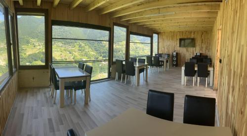 comedor con mesas y sillas y ventanas grandes en Yamaç Çam Hotel, en Trabzon