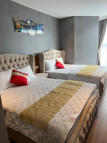 Ấp Thiẹn ÁiにあるKhách sạn 5* apec mandala Mui Né Phan Thiếtのベッド2台 ホテルルーム 赤い枕付