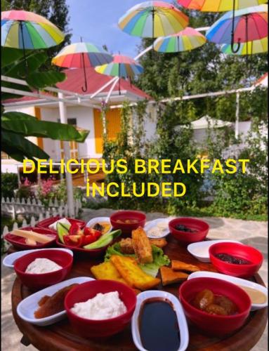 a table topped with bowls of food on a table with umbrellas at Qafqaz Fountain House in Gabala