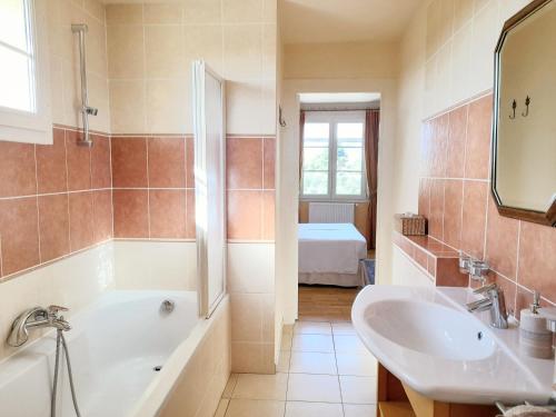 La salle de bains est pourvue d'une baignoire, d'un lavabo et d'un miroir. dans l'établissement Domaine Des Écureuils, à Carpentras