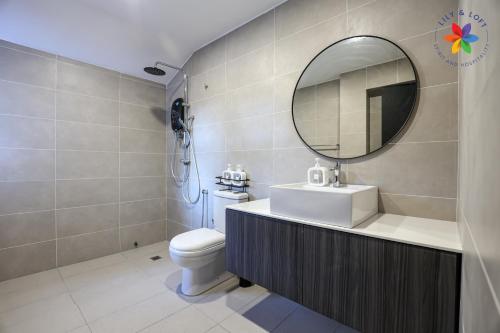 une salle de bain avec un lavabo et un miroir et des toilettes dans l'établissement KL Townhouse Villa by LilyandLoft, à Kuala Lumpur