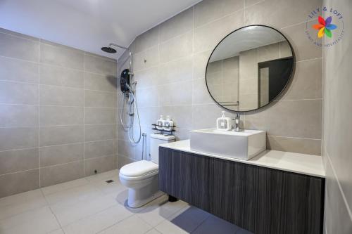 a bathroom with a sink and a mirror and a toilet at KL Townhouse Villa by LilyandLoft in Kuala Lumpur