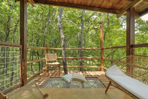 a screened in porch with a hammock and a chair at Agramada in Arnaia