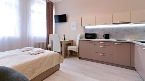 a room with a bed and a kitchen with a counter at 1868 Starke & Hoffmann by LC pokoje & apartamenty in Jelenia Góra