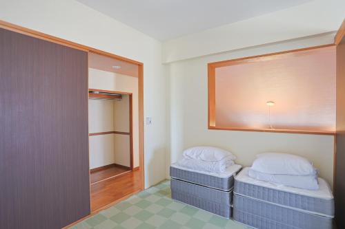 a room with two beds and a mirror at 南のヴィラ前浜 ~PCH~ #MPC in Miyako Island