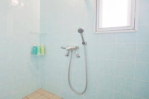 a shower in a bathroom with blue tiles at 南のヴィラ前浜 ~PCH~ #MPC in Miyako Island