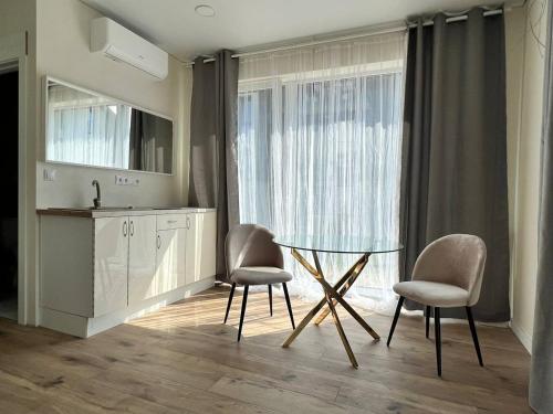 a kitchen with a table and two chairs and a sink at 4rest in Palanga