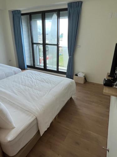 a bedroom with a bed and a large window at 安平包棟民宿 - 尋雨 - 部分日期可預定散房-台南民宿園景採光豪宅 in Tainan