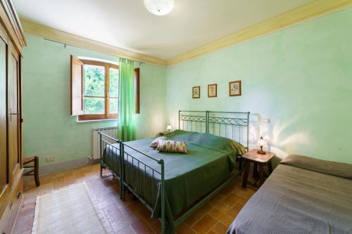 a green bedroom with a bed and a table at Agriturismo Ca'Mazzetto in Valfabbrica