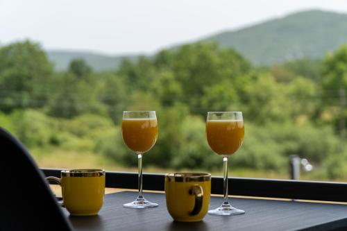 two wine glasses sitting on a table near a window at Plum house - villa with pool in Gospić