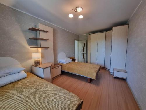 Cette petite chambre comprend deux lits. une table de nuit dans l'établissement Naftininkų g. 8, à Mažeikiai