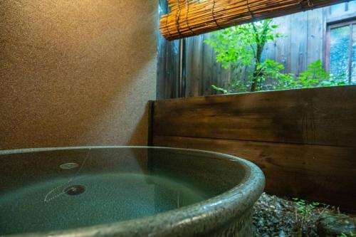 a bath tub in a bathroom with a window at 京·馨 in Kyoto