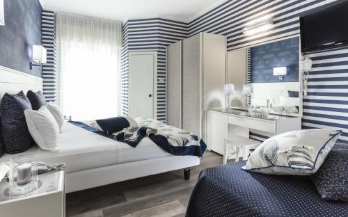 a bedroom with a bed and a desk in a room at Hotel Atlantic Riviera Mare in Misano Adriatico