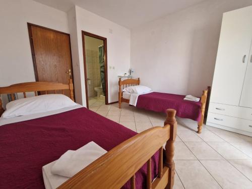 a bedroom with two beds and a bathroom at Old town - AP3 in Tribunj