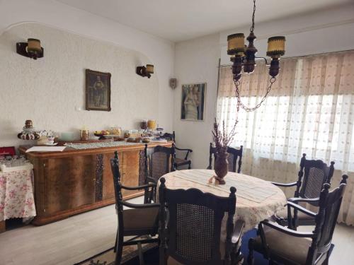a dining room with a table and a kitchen at Vila Monica in Târgu-Mureş