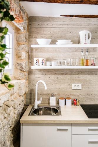 a kitchen with a sink and white shelves at Sv.Duje Apartments in Split