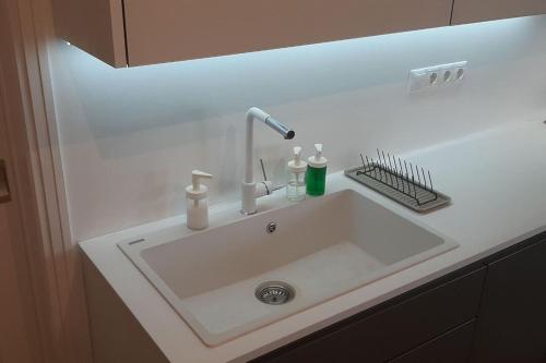 a white sink with a faucet on a counter at Το σπίτι του καπετάνιου στη Βουλιαγμένη in Athens