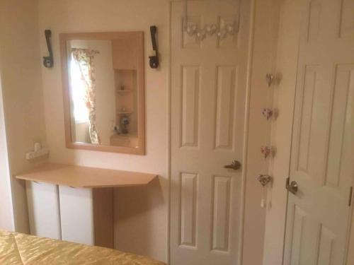 a bedroom with a mirror next to a door at Lakeland Retreat in Lamplugh