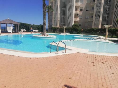 a large swimming pool in a large building at Apartamento playa Muchavista in El Campello