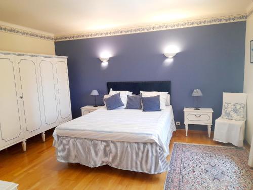 - une chambre bleue avec un grand lit et une chaise dans l'établissement Domaine Des Écureuils, à Carpentras