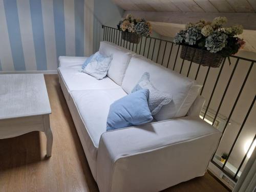 un sofá blanco con 2 almohadas en una habitación en Appartamento Shabby 123, en Grosseto