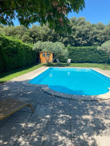 BédarridesSéde Vacante的花园内的游泳池,旁边设有长凳
