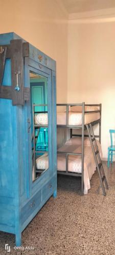 a bunk bed with a blue door and a bunk bed with a mirror at A Casa di Lu in Minervino di Lecce