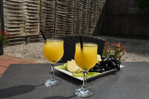 two glasses of orange juice and a tray of fruit at Boutique Hotel Ukus in Tešanj