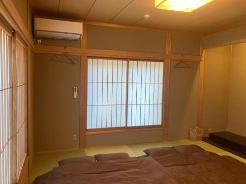 a bedroom with a bed and a large window at YUFUIN YUKI-AN in Yufuin