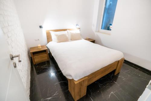 Cette petite chambre comprend un lit avec des draps blancs et une fenêtre. dans l'établissement Guest Studio, à Braşov